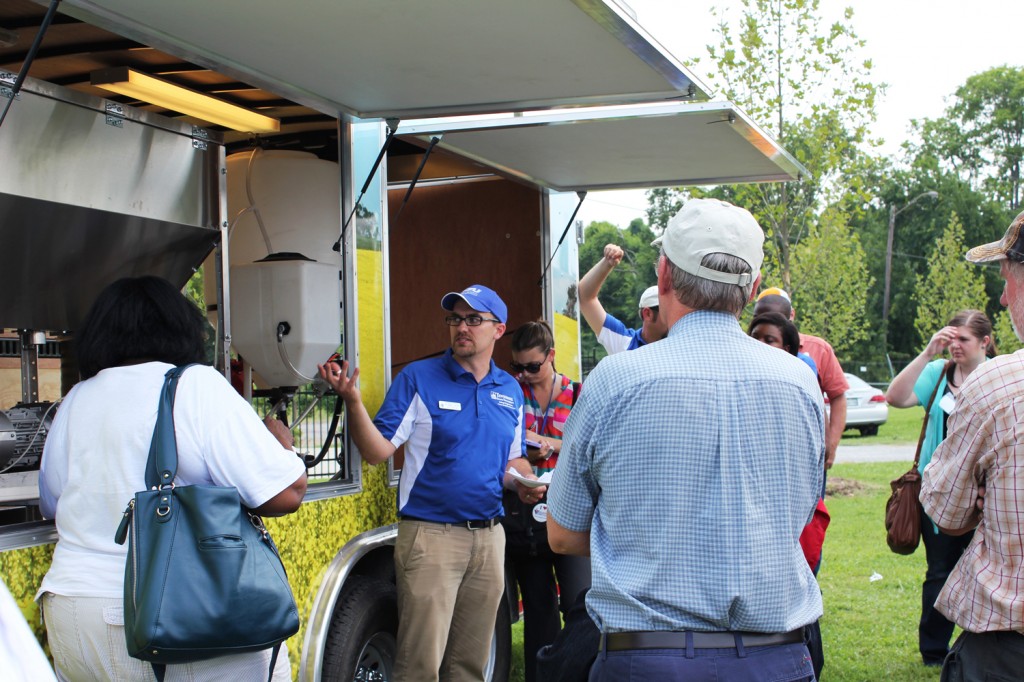 Dr. Jason de Koff (center), assistant professor of agronomy and soil sciences at TSU, shares bioenergy research with visitors recently. The mobile demonstration lab will be on display at the Tennessee State Fair Sept 6-15. (courtesy photo)
