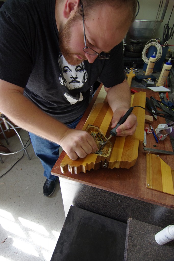 Using basic tools, Allen changes out one of the electric capacitors in the bass guitar he built. The guitar build, which started out as a rough sketch on paper, took more than two-and-a-half months to create. (photo by Rick DelaHaya, TSU Media Relations)