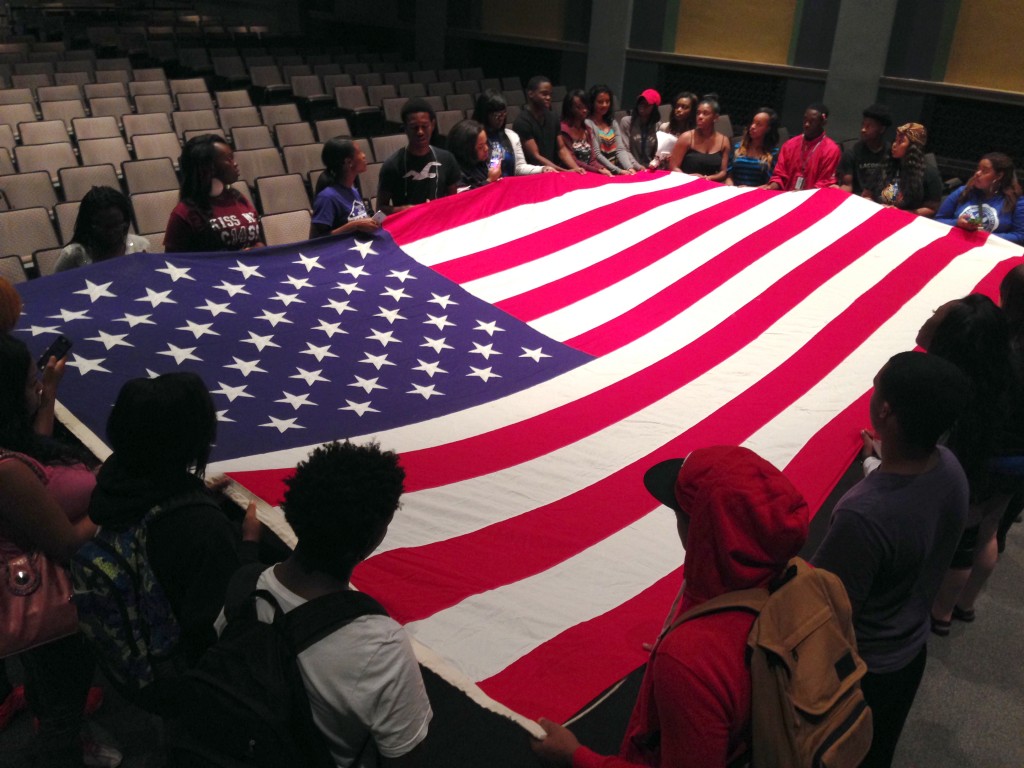 First-time freshmen gather around an American flag in Paog Auditorium to share tributes and personal stories to honor those who died during the 9/11 attacks. (photo by Rick DelaHaya, TSU Media Relations) 