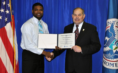 Thomas Graham, assistant director of Emergency Management at Tennessee State University, receives his certificate of training from Edward Smith, acting deputy superintendent at FEMA’s Emergency Management Institute. Graham graduated from the Agency’s Basic Academy Dec. 18, 2014. 
