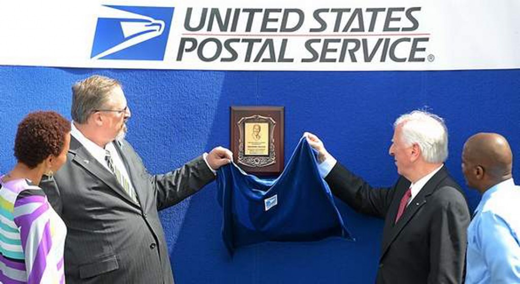 U.S. Rep. Mike Thompson, right and Bay Valley District Manager of the USPS Jeffrey Day, left,  along with Deidre Graham and her brother Montoya unveil a plaque renaming the Springstowne Center Post Office after Philmore Graham. (Photo courtesy of CHRIS RILEY—VALLEJO TIMES-HERALD)